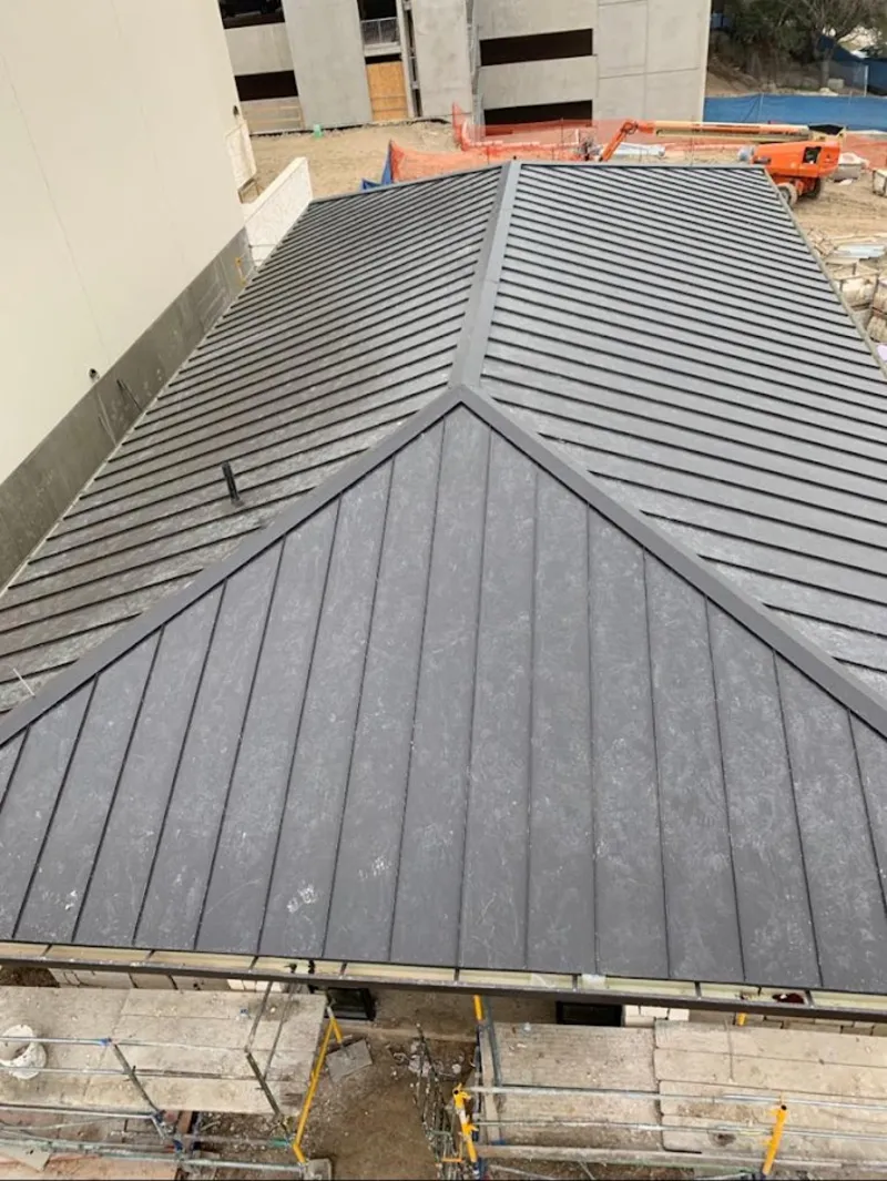 Commercial metal roof construction with crane equipment in Sterling Heights